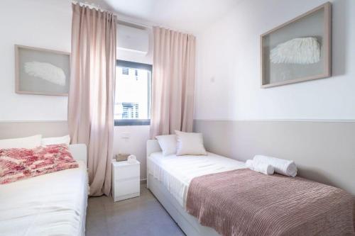a bedroom with two beds and a window at Luxury 4 Bedroom With Amazing View In Ramat Sharet Bayt Vegan in Jerusalem