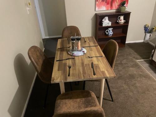 a wooden table and chairs in a living room at Victoria house in Geraldine