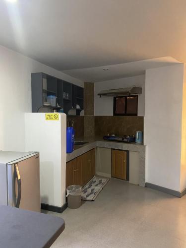 an empty kitchen with a refrigerator in a room at Dante's Hideaway Guest House in Boracay