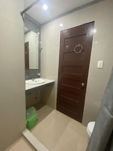 a bathroom with a brown door and a sink at Dante's Hideaway Guest House in Boracay