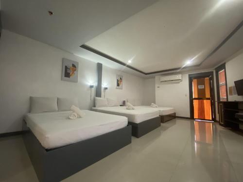 a hotel room with two beds and a television at Dante's Hideaway Guest House in Boracay