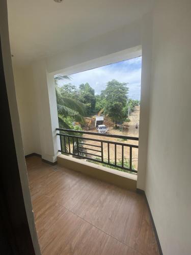 an empty room with a large window and a balcony at Dante's Hideaway Guest House in Boracay