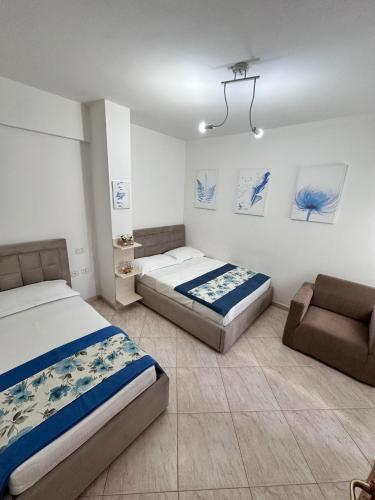 a bedroom with two beds and a couch in it at AURI'S HOUSE in Vlorë