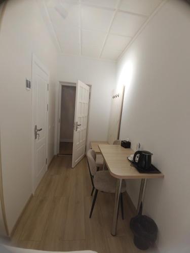 a room with a desk and a table with a chair at MIMFRI guest house,hotel in Tashkent