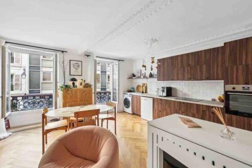 une cuisine et une salle à manger avec une table et des chaises dans l'établissement Design appartement in Le Marais, à Paris