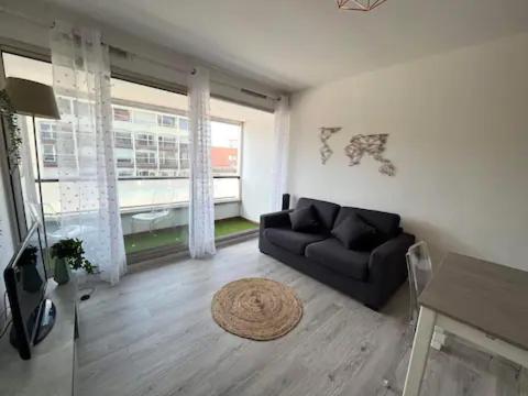 - un salon avec un canapé noir et une cheminée dans l'établissement Manon, au Cap d'Agde