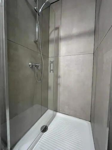une douche avec une porte vitrée dans une salle de bain dans l'établissement Manon, au Cap d'Agde