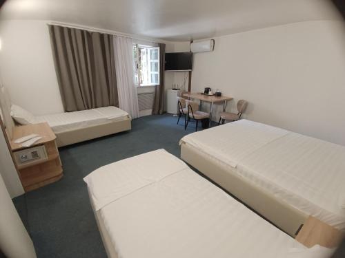 a hotel room with two beds and a table at MIMFRI guest house,hotel in Tashkent