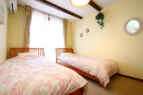 a bedroom with two beds and a window at Pension Ivy in Yamanakako