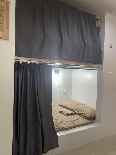 a room with a bed in a display case at Dante's Hideaway Guest House in Boracay