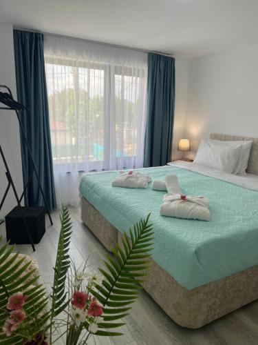 a bedroom with two beds and a large window at Guest house Villa Orlovo in Orlovo