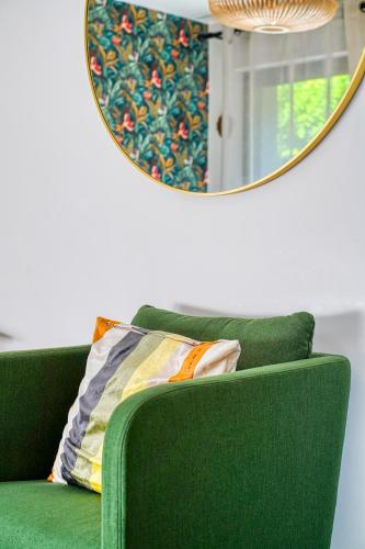 a green couch in front of a mirror at Superbe studio avec terrasse in Brunoy