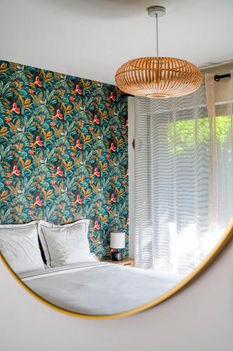a bedroom with a large bed with a floral wallpaper at Superbe studio avec terrasse in Brunoy