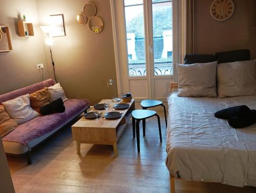 - un salon avec un lit et une table basse dans l'établissement 520 grand studio en hypercentre, à Reims