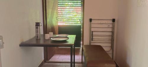 a room with a table and a chair and a window at Gangadharam Tiny House 2BHK AC in Tellicherry