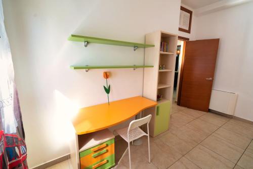 a room with a desk with a flower on it at Appartamento Sermoneta - vicino Stazione FS - Warm in Monticchio