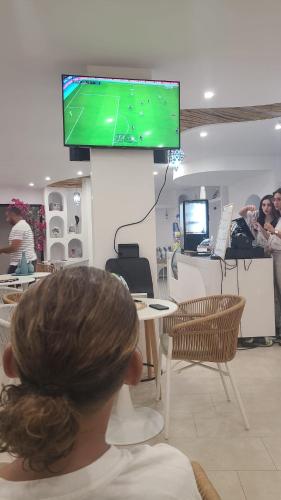 a person sitting at a table with a tv in a store at Wave in Sidi Bou Ali