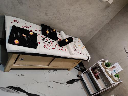 a bed with black and white sheets and flowers on it at XCELSIOR HOTEL & SPA in Shillong