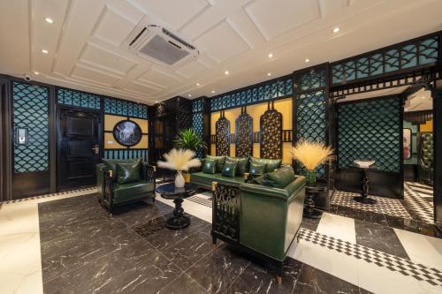 a lobby with a couch and a clock on the wall at Madelise Grand Hotel in Hanoi