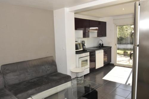 un salon avec un canapé et une cuisine dans l'établissement Bas de Villa tropicale SANARY, à Sanary-sur-Mer