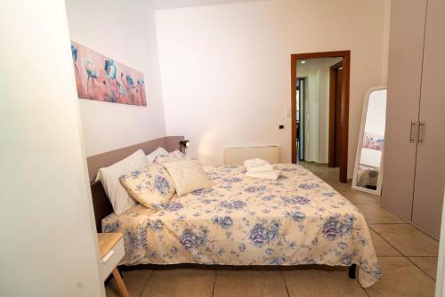 a small bedroom with a bed with a floral bedspread at Appartamento Sermoneta - vicino Stazione FS - Warm in Monticchio