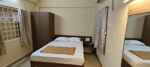 德瓦尔卡Hotel TGP The Grand Praatap的有两张床和一扇窗户的小房间