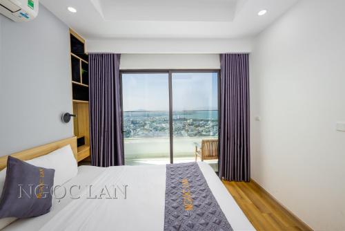 a bedroom with a bed and a large window at TMS Quy Nhon - Ngoc Lan Apartments in Quy Nhon