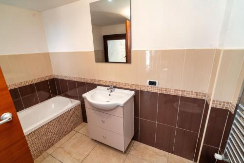 a bathroom with a sink and a bath tub at Appartamento Sermoneta - vicino Stazione FS - Warm in Monticchio