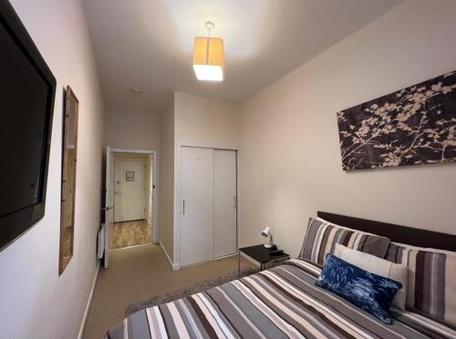 a bedroom with a bed and a tv in a room at Charming 2-Bedrooms City Centre Apartment-No Party in Aberdeen