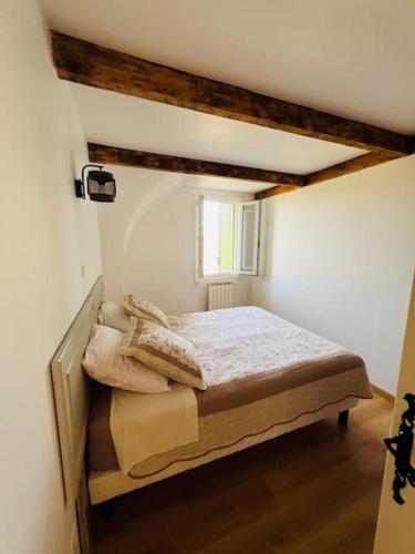 une petite chambre avec un lit dans une pièce dans l'établissement Le Gîte Mas de Novis Vieux Mas du XVIIIe siècle, à Saint-Hilaire-de-Brethmas