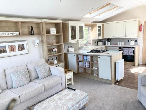 a living room with a couch and a kitchen at Vogue at Primrose in Reighton