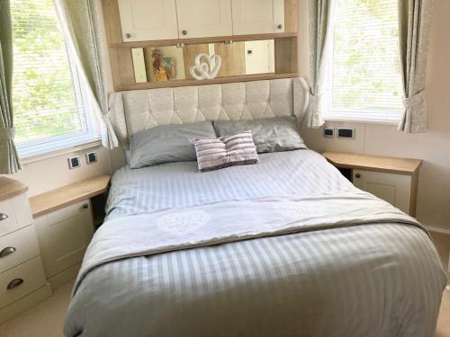 a bed in a bedroom with two pillows on it at Vogue at Primrose in Reighton