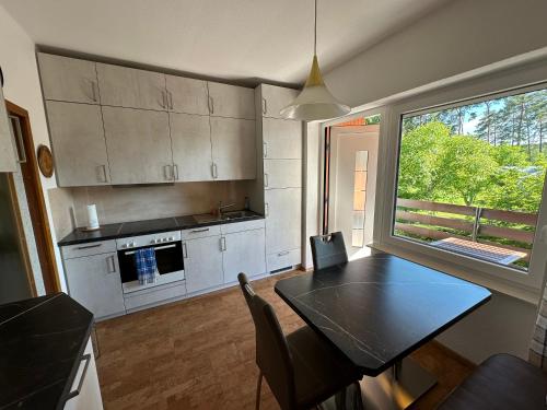 a kitchen with a table and a large window at Ferienhaus Annerose in Wendisch Rietz