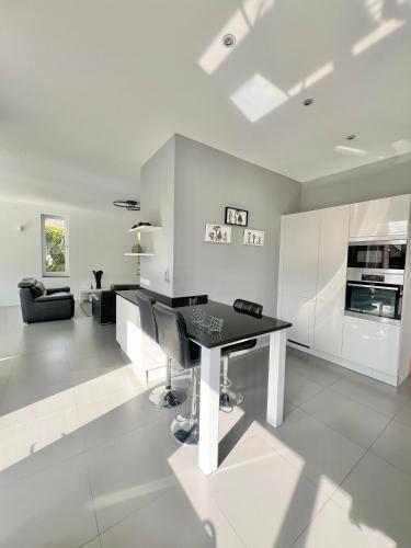 a white kitchen with a black desk in a room at Moderne Villa aux portes de Bruxelles! in Grimbergen