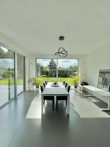 a white living room with a table and chairs at Moderne Villa aux portes de Bruxelles! in Grimbergen