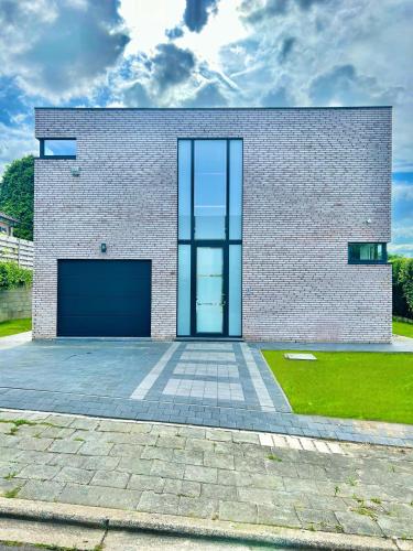 a brick house with a large garage at Moderne Villa aux portes de Bruxelles! in Grimbergen