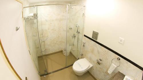uma casa de banho com uma cabina de duche em vidro e um WC. em Nala Hotels em Nāmakkal
