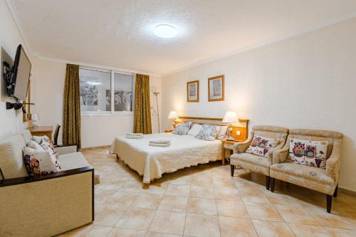 una camera d'albergo con un letto, un divano e un tavolo di Villa with private pool and beautiful garden a Los Cristianos