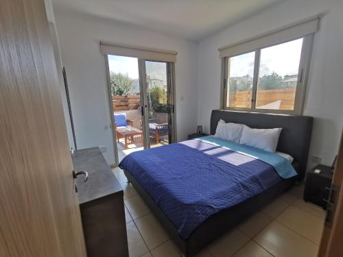 a bedroom with a bed with a blue blanket at Sunny coast apartment by the sea in Protaras