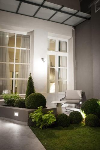 a bench sitting in the middle of a garden at Hotel La Lanterne & Spa By Timhotel in Paris