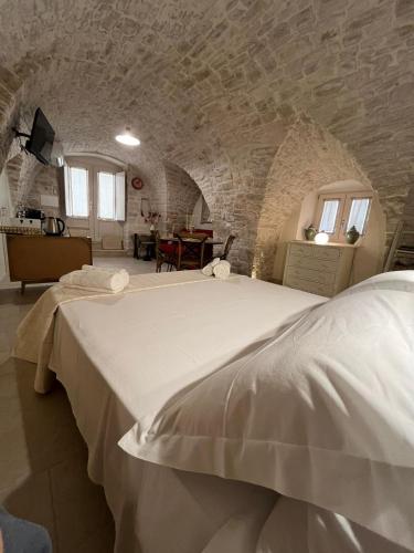 a bedroom with a large white bed in a stone wall at Zia Giacomina's House in Cassano delle Murge