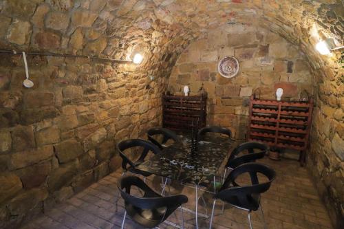 a dining room with a table and chairs in a stone wall at Palócliget Vendégház in Kétbodony