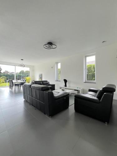 a living room with two couches and a table at Moderne Villa aux portes de Bruxelles! in Grimbergen