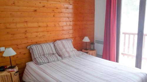 - une chambre avec un lit et un mur en bois dans l'établissement Appartement de standing 4 personnes, pied des pistes, parking, aux Angles
