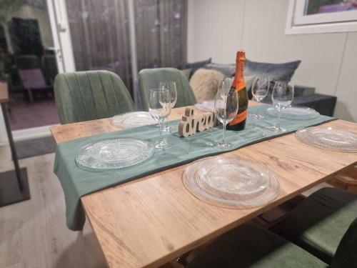 a table with glasses and a bottle of wine on it at Emerald Chalet Bran in Bran
