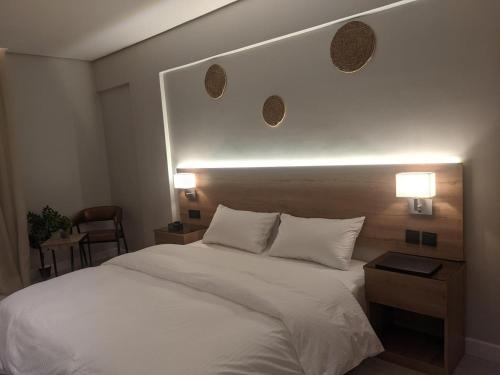 a bedroom with a large white bed with two lamps at سدارا للأجنحه الفندقيه in Riyadh
