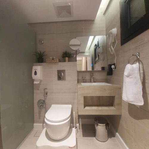 ein Badezimmer mit weißer Toilette und Waschbecken in der Unterkunft سدارا للأجنحه الفندقيه in Riad