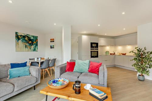 a living room with two couches and a table at 1 Rockham - Luxury Apartment at Byron Woolacombe, only 4 minute walk to Woolacombe Beach! in Woolacombe