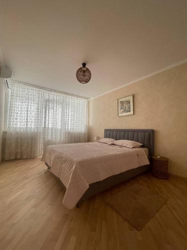 a bedroom with a bed and a large window at Park view spacious apartment in Sectorul Botanica