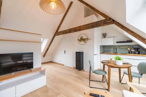 a kitchen and living room with a table and chairs at Studio Charmant -Cœur de Lannion - Tout equipé in Lannion